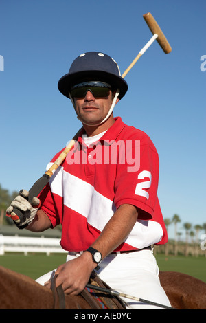 Polo Player holding polo stick on horseback on polo field Stock Photo