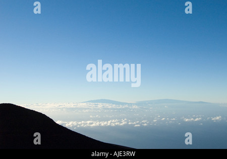 Sunrise (dawn) at the summit of Haleakala Volcano National Park, Maui, Hawaii, with Big Island in the distance Stock Photo