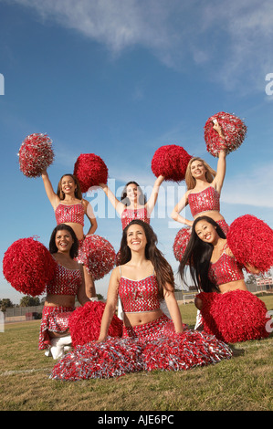 Cheerleaders posing with pom poms in group Stock Photo