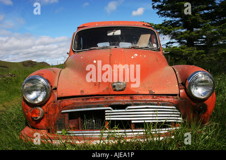 a rusty old car sitting on the ground on a farm in Iceland Stock Photo