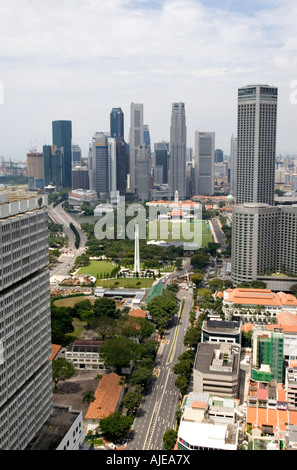Bank and financial company tower buildings beyond white Civilian War Memorial and Padang cricket pitch Singapore Stock Photo