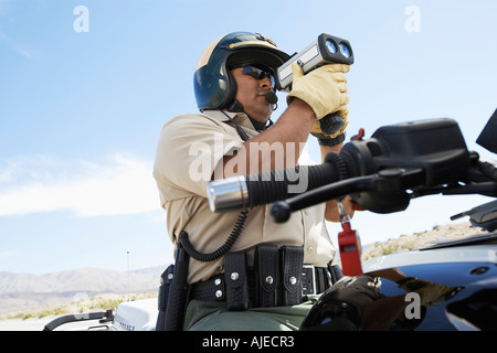 Police officer using radar gun Stock Photo
