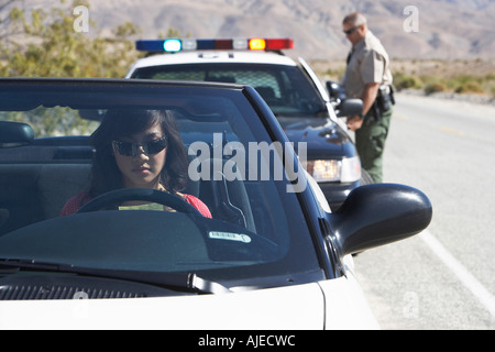 Women sitting in car being pulled over by police officer Stock Photo