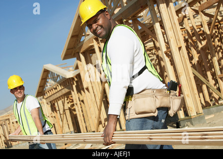 Construction workers carrying boards at construction Site Stock Photo