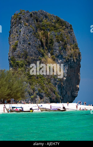 Tall rock towers over white sand of popular Ko Poda island off Ao Nang beach Thailand