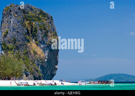 Tall rock towers over white sand of popular Ko Poda island off Ao Nang beach Thailand