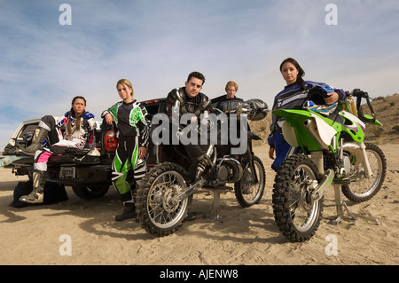 Motocross racers with bikes in desert, (portrait) Stock Photo