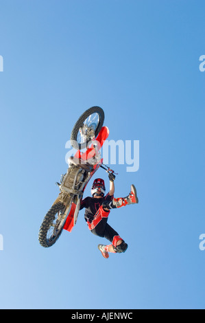 Freestyle motocross racer performing stunt in air Stock Photo