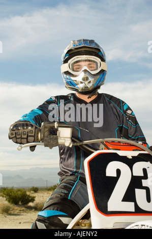 Motocross racer on bike in desert, (portrait) Stock Photo