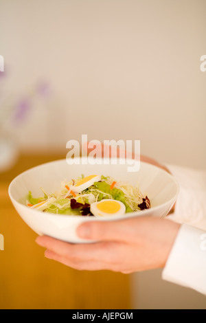 Young woman holding bowl of salad Stock Photo
