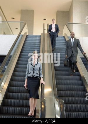 Businesspeople on escalators Stock Photo