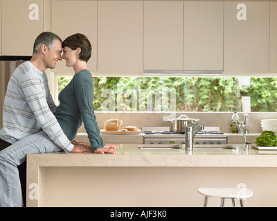 Smiling couple flirting in kitchen Stock Photo