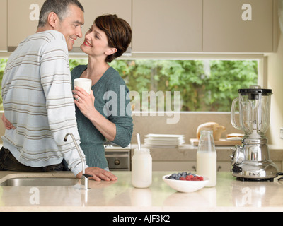 Smiling couple flirting in kitchen Stock Photo