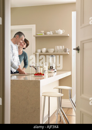 Smiling couple in kitchen, seen through open door Stock Photo
