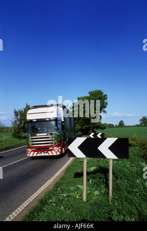 lorry passing black and white warning chevron sign warning of sharp bend in the road ahead leeds yorkshire uk Stock Photo