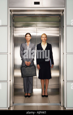 Businesswomen Side by Side in Elevator, portrait, front view Stock Photo