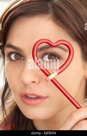 Woman holding heart shape pencil Stock Photo