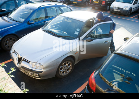 A thief breaking into a car Stock Photo
