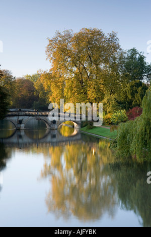 Ancient Clare bridge with autumn colours and reflections bathed in early morning sunlight on the river Cam Cambridge Stock Photo