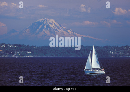 Sailboat On Puget Sound With Mt Rainier and West Seattle Alki beach shorline In Distance Seattle Washington Stock Photo