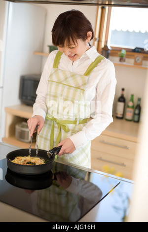 Young woman cooking spaghetti Stock Photo