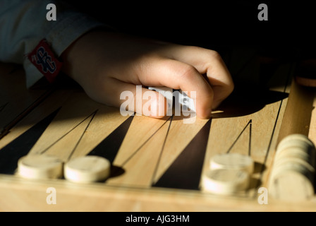 Stock Photo of a backgammon baord The image shows a childs hands just reaching for the dice Stock Photo