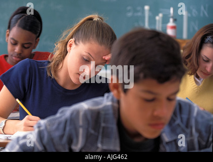 Latino African American and Caucasian high school students  concentrating end working at desks in class Stock Photo