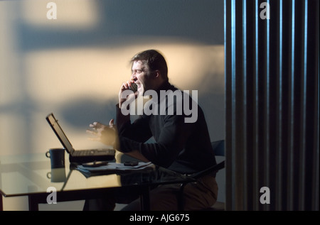 Caucasian businessman yelling on phone in home office Stock Photo