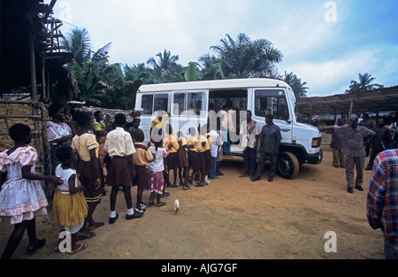 School children getting on school bus Teberebie village Western Ghana Ashanti Region Stock Photo