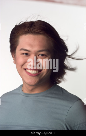 Portrait Asian man smiling with hair blowing Stock Photo