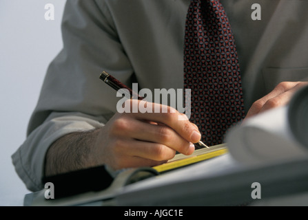 Caucasian businessman writing notes at meeting Stock Photo