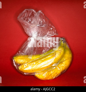 A bunch of bananas in a plastic bag showing unnecessary and environmentally damaging packaging Stock Photo