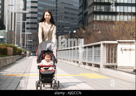 Businesswoman pushing baby stroller Stock Photo