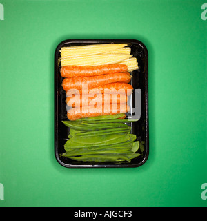 Mixed vegetables rowed up in a plastic tray showing unnecessary and environmentally damaging packaging Stock Photo