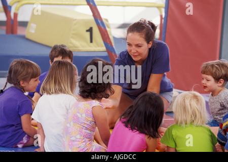 Caucasian teacher talking to students in preschool gym class Stock Photo