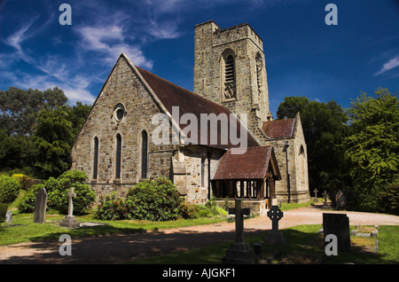 Picturesque Fairwarp Church with Blue Sky Trees in background and silhouetted gravestones in foreground Stock Photo