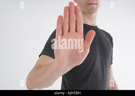 Man showing stop gesture on grey gradient background, double exposure ...