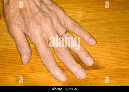 Senior female hand (ninety years plus) on pine table top. Aging process. Healthcare. Stock Photo