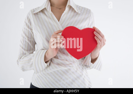 Businesswoman holding heart-shaped box Stock Photo