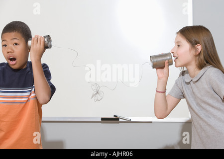 Children using tin can phone Stock Photo