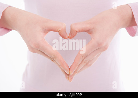 Woman making heart shape with her hands Stock Photo