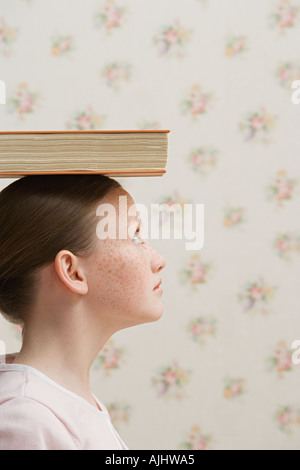 Girl balancing a book on her head Stock Photo