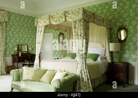 Bedroom with fourposter bed and green patterned wall paper in 17th century Irish castle Stock Photo
