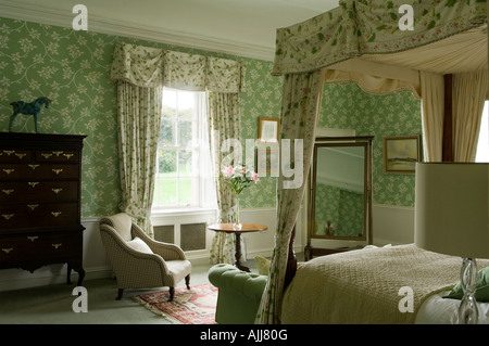 Bedroom with fourposter bed and green patterned wall paper in 17th century Irish castle Stock Photo