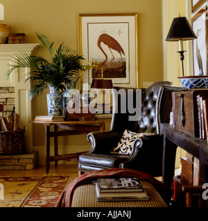 Living room with regency leather wing armchair, bookshelf and artwork Stock Photo