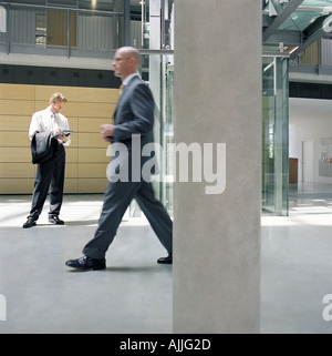 Businessmen in office lobby Stock Photo
