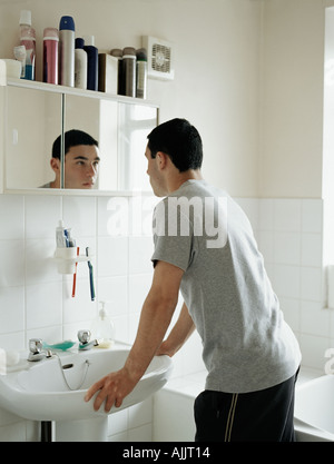 Teenage boy standing in bathroom Stock Photo