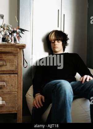 Teenage boy sitting on a beanbag Stock Photo