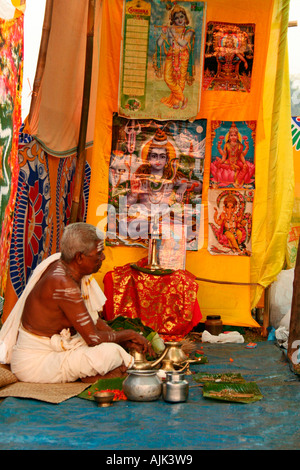 Pujari or Hindu priest performing rituals for pilgrims in the predawn ...