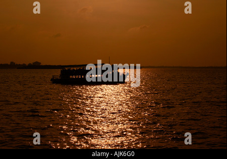 A boat carrying passengers floating in the majestic waters of Vembanad lake in Cochin, 'the Queen of Arabian Sea' Stock Photo